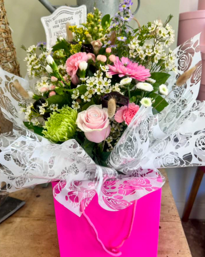 Blushing Meadow - A stunning collection of pink and green seasonal flowers in toning packaging. This bouquet is designed to impress and uplift any space.