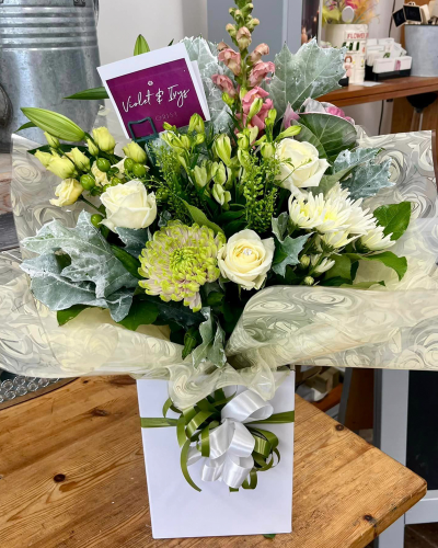 Classic Harmony - Share your sentiments with this beautiful arrangement of white and green blooms complemented by lush greenery. Presented in elegant wrapping.